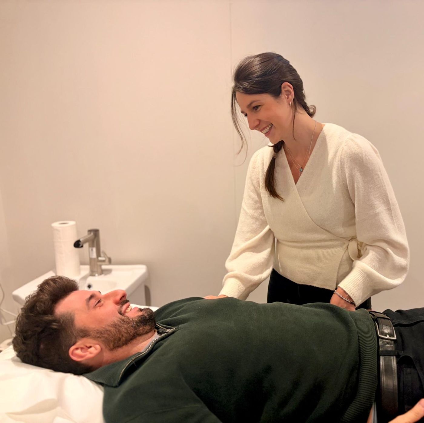 Ali smiling with a relaxed client during an acupuncture treatment